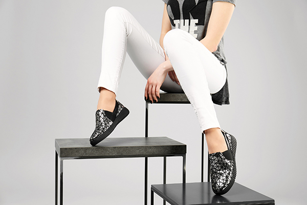 Woman in stylish shoes with stands on grey background, closeup